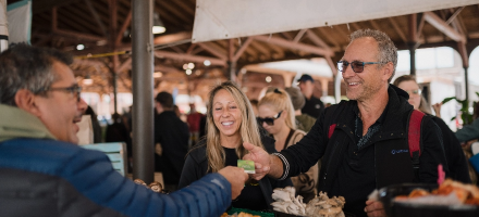 Smiling couple paying vendor with credit card at Eastern Market in Detroit